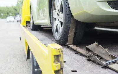 Wheel-lift tow truck securing an AWD vehicle in New Orleans